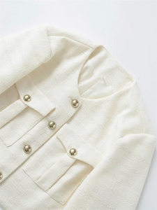 Nahaufnahme einer beigen Tweedjacke mit eleganten Goldknöpfen und gewebter Textur