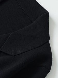 Detailansicht eines schwarzen Polo-Strickkragens mit feiner Textur und hochwertiger Naht