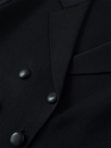 Detail von Reverskragen und Lederknöpfen an einem schwarzen Strick-Cardigan-Blazer