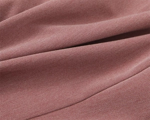 Dettaglio macro del tessuto in twill rosa polvere per eleganti pantaloni dritti donna