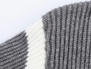 Dettaglio maglione in maglia a coste grigie con morbida trama in mohair e strisce bianche