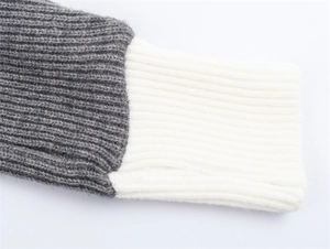 Dettaglio dei polsini in maglia a coste bicolore del cardigan con collo alto