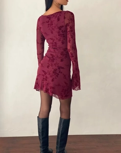 Macro shot of burgundy mesh dress featuring elegant floral flocking and bell sleeves detail