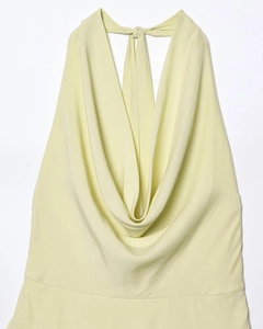 Detalle del elegante cuello drapeado en un vestido halter amarillo claro con espalda al aire
