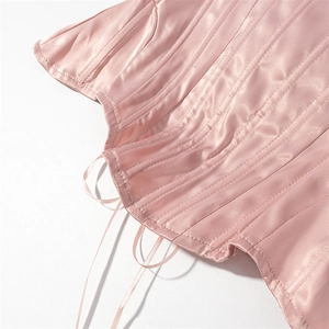 Detail of pink satin corset top showing boning structure and lacing metal eyelets