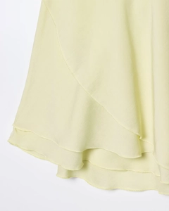 Detalle de falda de gasa amarillo claro con volantes en capas y textura suave