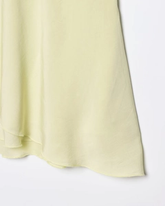 Detalle del dobladillo del vestido de gasa verde claro con costura remallada fina
