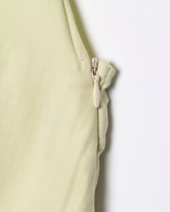 Detalle de cremallera invisible en vestido verde claro con espalda descubierta