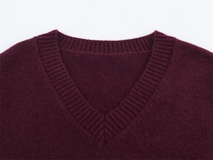 Dettaglio ravvicinato dello scollo a V a costine sul maglione in maglia bordeaux