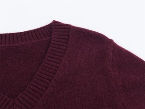 Dettaglio macro del collo a V e trama della maglia morbida color bordeaux