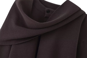 Detail of dark coffee knitted jacket with textured scarf collar and elegant black button