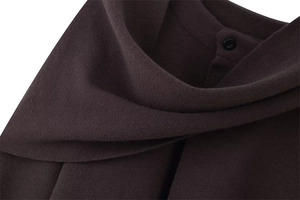 Detail of dark brown knit cardigan with ribbed texture and small black button closure