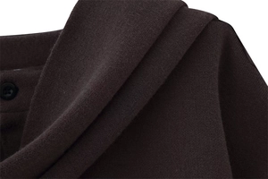 Macro detail of dark brown knit cardigan showing tight weave texture and black button