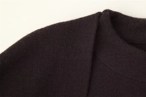 Detail of dark brown knit cardigan collar showing fine wool texture and premium craftsmanship