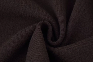 Macro shot of dark brown ribbed knit fabric showing soft texture and premium quality fiber