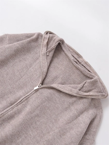 Detail of light brown chunky knit sweater with silver metal zipper and lapel collar