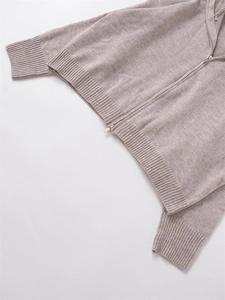 Close-up of light grey knit hoodie featuring ribbed cuffs and silver metal zipper detail