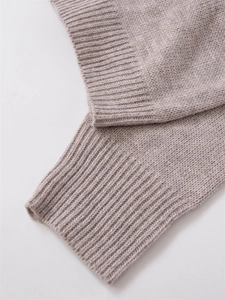 Close-up of ribbed cuffs and fine knit texture on an oatmeal-colored cardigan sweater