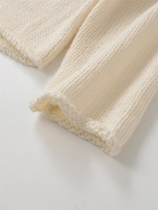 Gros plan du poignet d'un pull en maille crème avec un bord festonné élégant et raffiné