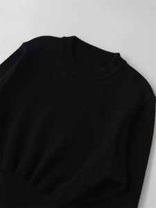 Detail of classic black crewneck knit sweater showing ribbed neckline and fine texture