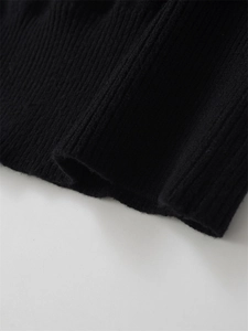 Detailed macro view of black rib-knit texture on long sleeve cuffs and hemline
