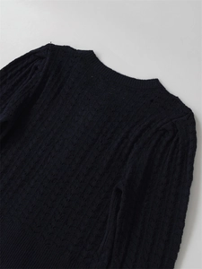 Détails du tricot torsadé et du col rond sur ce pull en maille bleu foncé de haute qualité