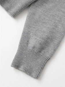 Detail view of the ribbed cuffs on a grey knit hoodie with soft wool texture