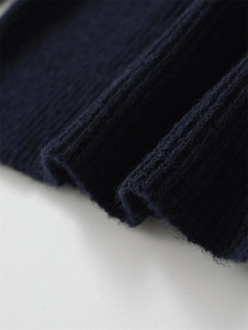 Vue macro d'un tricot côtelé épais montrant la texture bleu foncé en laine mélangée