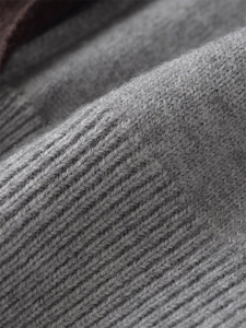 Macro view of grey ribbed knit fabric texture showing soft wool-like fuzzy details
