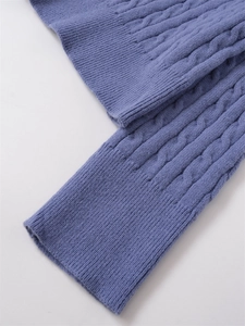 Dettaglio della trama a treccia color lavanda e polsini a coste di un maglione da donna