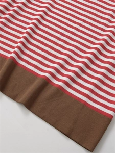 Detail of red and white striped knit sweater showing brown ribbed hem and fabric texture