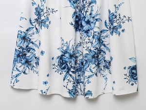 Gros plan d'imprimés floraux de lys bleus sur mousseline blanche avec drapé élégant