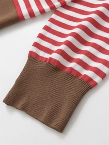 Detailed close-up of the red and white striped knit top with brown ribbed elastic cuffs