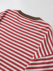 Detail of red and white striped knit sweater showing brown ribbed crew neck texture