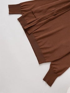 Macro detail of brown knit sweater showing ribbed cuffs and soft fabric texture