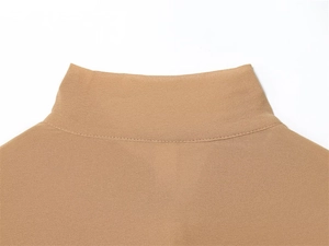 Dettaglio macro del colletto con fiocco e cuciture su camicetta in chiffon kaki