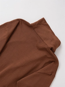 Detail shot of the ribbed knit texture and high turtleneck on a brown sweater