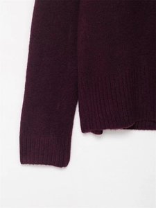 Gros plan détaillé des poignets et de l'ourlet côtelés sur le pull en maille violet foncé
