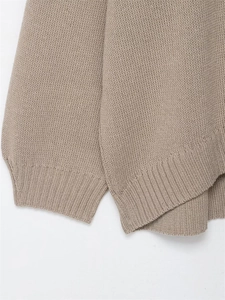 Detail of light coffee knitted sweater featuring ribbed cuffs and fine fabric texture