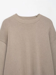 Close-up of light brown knit sweater showing chunky texture and ribbed crew neck details