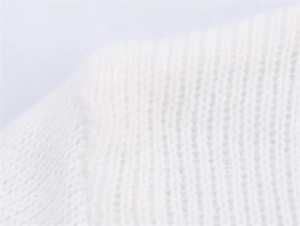 Makrodetail der weißen Rippstrick-Stofftextur an diesem süßen Herbst-Strickjacke