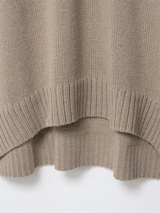 Close-up of khaki knit sweater showing ribbed hem and high-low asymmetrical design