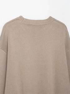 Detail of khaki knit sweater showing ribbed crew neck and drop shoulder construction