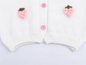 Detailansicht der weißen Strickjacke mit gehäkelten Erdbeeren und rosa Knöpfen für Damen