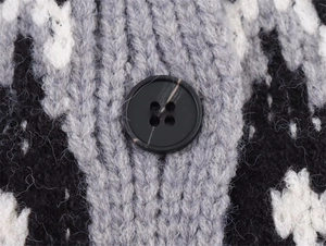 Close-up of geometric jacquard knit fabric and marble texture button on autumn cardigan