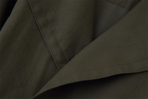 Detail of olive green twill fabric with reinforced double stitching for autumn jacket