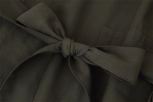 Detailed view of the knotted olive green trench coat belt with premium twill fabric texture