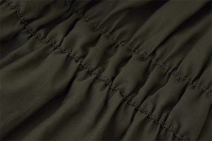 Detail of olive green twill fabric showing exquisite shirring and elastic stitching details