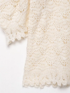 Detail der aufwendigen Lochstrickerei und Wellenkante an dem cremefarbenen Strickpullover