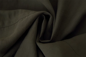 Detail of dark olive green twill fabric with visible fine stitching and durable texture